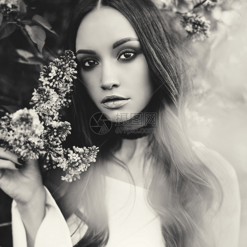 黑白户外时尚照片,美丽的轻女人被丁香花包围春天开花了图片