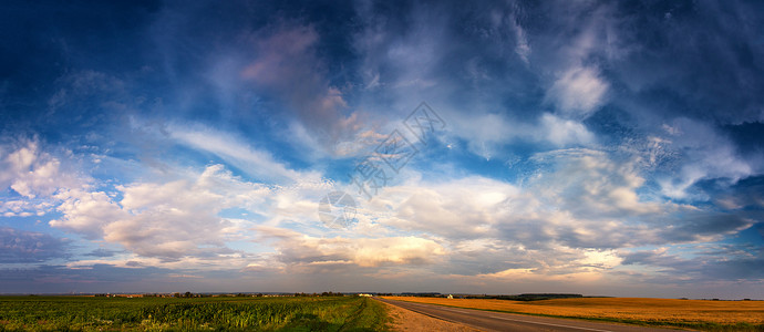 夏天的道路下可怕的云天空全景暴风雨后夏天穿过田野背景图片
