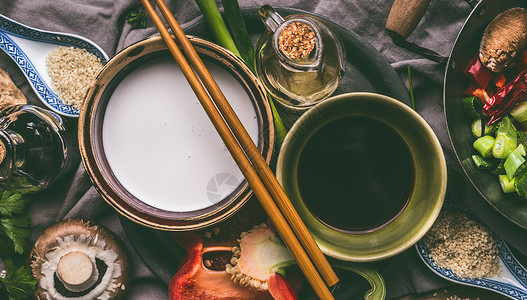 碗与椰奶,酱油,芝麻油,筷子蔬菜厨房的桌子背景,顶部视图亚洲食品烹饪原料,中国泰国菜的背景图片