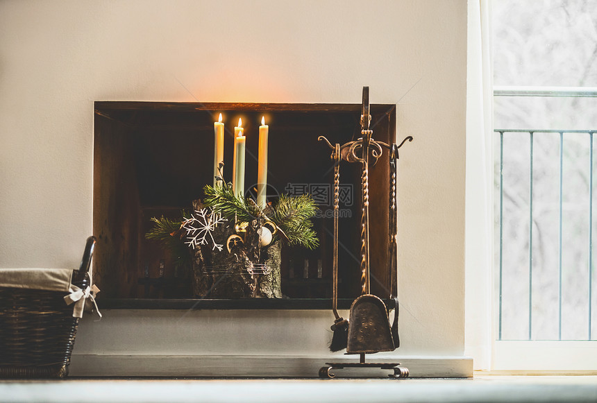 冬季舒适的家居装饰节日气氛,燃烧的蜡烛,冷杉树枝雪花壁炉客厅的窗户装饰四个降临花圈图片