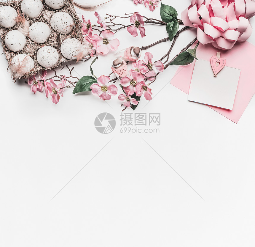 粉粉复活节贺卡模拟与鲜花装饰,鸡蛋纸箱白色书桌背景,顶部视图,平躺,边框图片