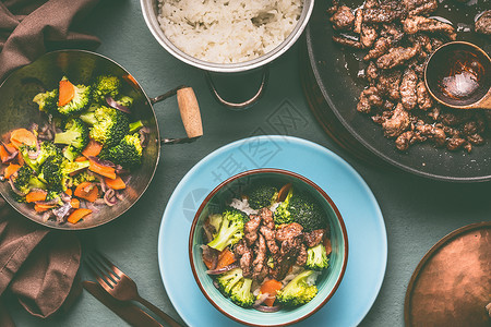 健康均衡的营养盘锅碗与牛肉,蒸蔬菜米饭桌子背景与盘子餐具,顶部的视图图片