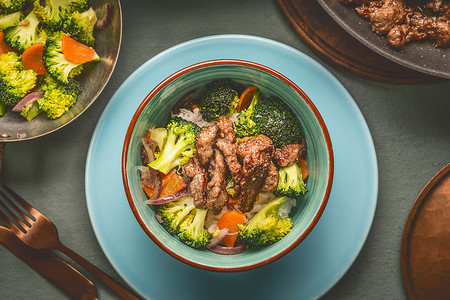 健康平衡营养餐碗与牛肉,大米,蒸蔬菜西兰花胡萝卜与盘子餐具,顶部视图图片