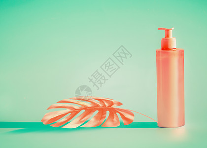 粉红色化妆瓶与配药泵热带叶薄荷背景夏季护肤防晒霜产品与的图片