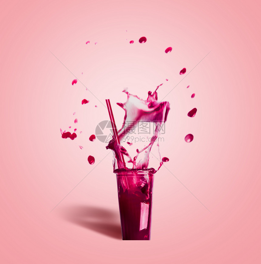 璃与饮用吸管紫色飞溅夏季饮料冰沙果汁粉红色背景,正视图图片