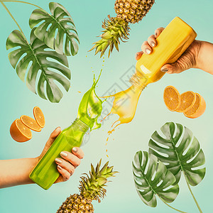 夏季饮料的女手瓶与飞溅的冰沙果汁蓝色背景与热带树叶水果图片