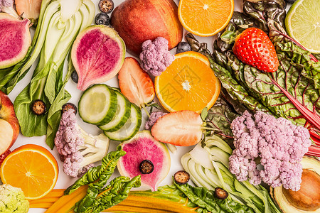 五颜六色的水果蔬菜背景与半的橘子,浆果,顶部的景色健康食品清洁饮食成分的图片