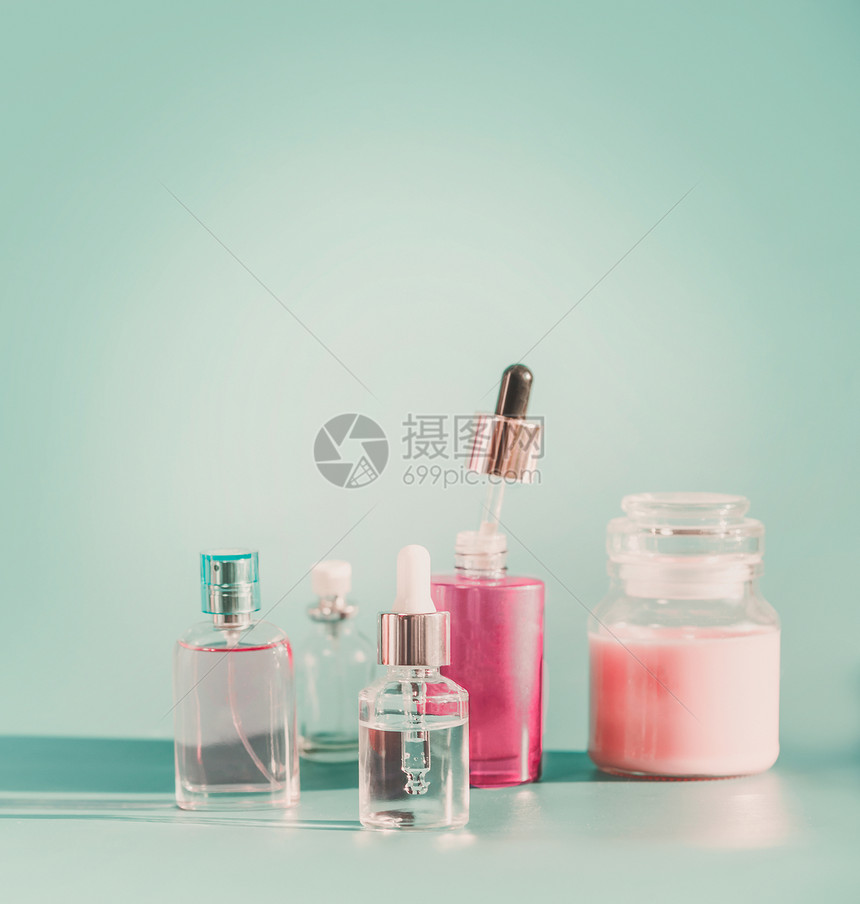 套现代部护肤化妆品蓝色背景产品瓶与滴管吸管,雾喷雾,血清保湿璃瓶前的风景品牌模型图片