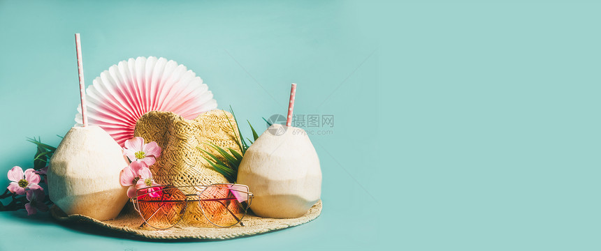 海滩配件草帽,棕榈叶,粉红色太阳眼镜,蓝色绿松石背景上的花椰子鸡尾酒,顶部景色暑假热带假期旅游理念,横幅图片