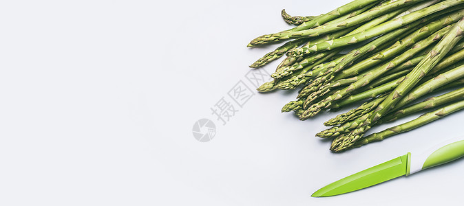 绿色芦笋与菜刀白色背景,顶部视图,平躺健康的季节食物图片
