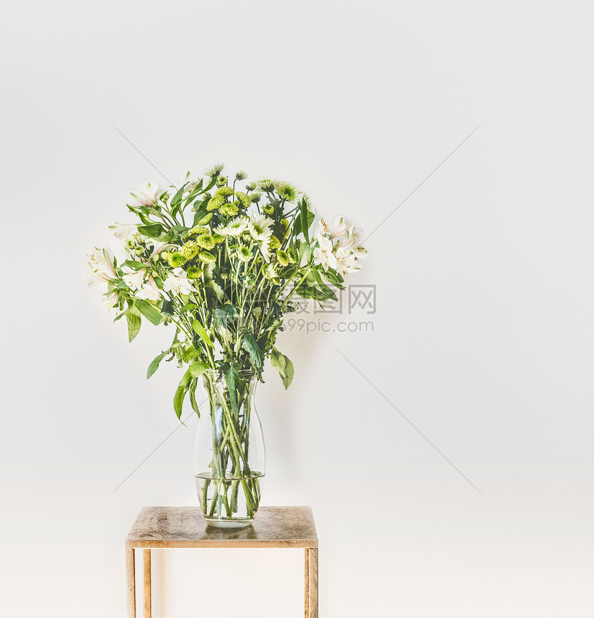 美丽的绿色花与飘落的花瓣璃花瓶白色的墙壁背景家庭内部装饰的想法图片