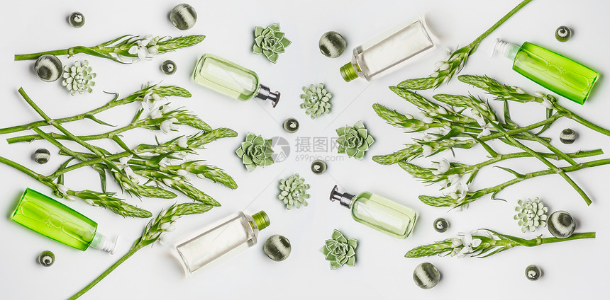 绿色草药纯素天然化妆品与瓶护肤品与品牌,草药花白色背景,顶部视图,平躺美丽的图片