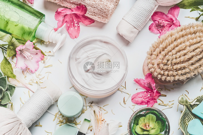 护肤霜与鲜花,花瓣等身体护理化妆品配件的白色背景,顶部视图图片