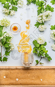 蜂蜜污渍罐子与花蜂蜜梳子白色背景,顶部视图图片