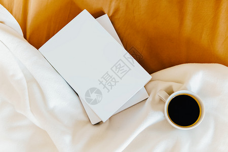 周末床上用咖啡杯好书放松图片
