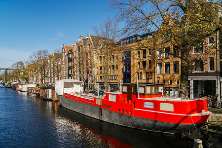 秋天阿姆斯特丹运河上荷兰房屋游艇的美丽建筑图片