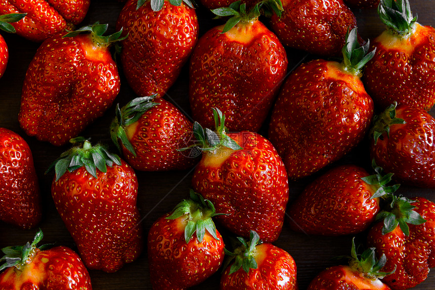 成熟多汁的草莓放篮子里的木桌上图片