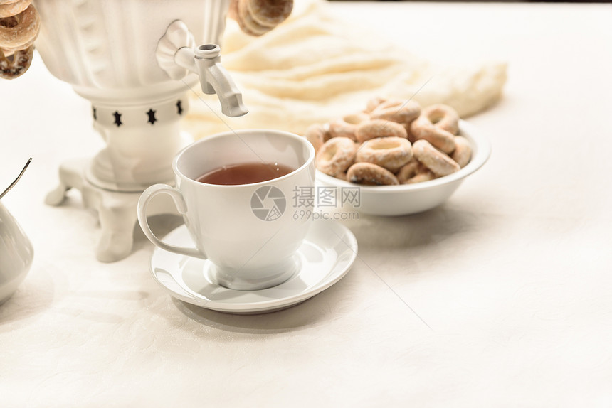白色桌布上百吉饼热茶的萨莫瓦尔图片