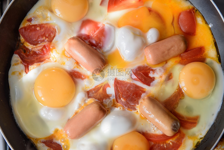 煎鸡蛋,香肠西红柿热锅上,烹饪早餐图片