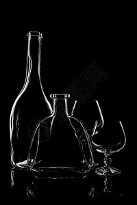 透明的白兰地瓶,背景为黑色,反光高清图片