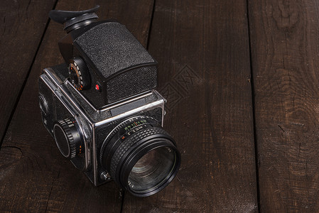 老式黑色胶卷相机棕色背景的天然木材与镜头图片