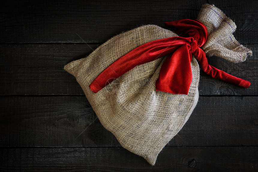 木制背景上红色丝带的诞礼品袋图片