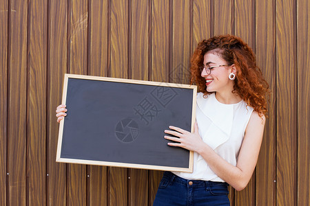 轻的女人用黑板教书图片