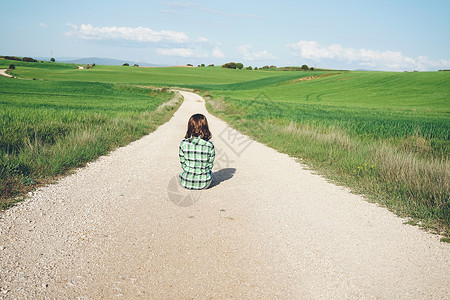 个轻女人独自绿色的田野里的背影图片