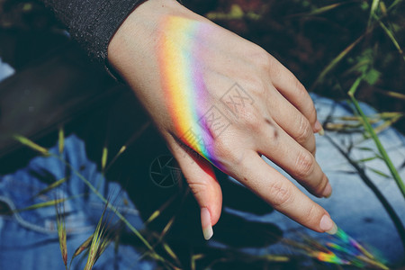 女手中的彩虹光背景图片