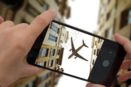 用智能手机拍摄架飞越城市的飞机拍摄架飞行飞机图片