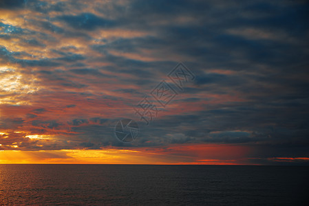 日落海里五颜六色的水云日落海里背景图片