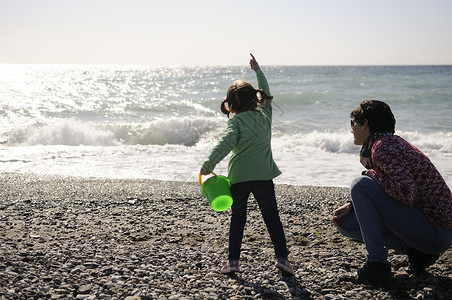 冬天,妈妈小女儿海滩上玩得很开心图片