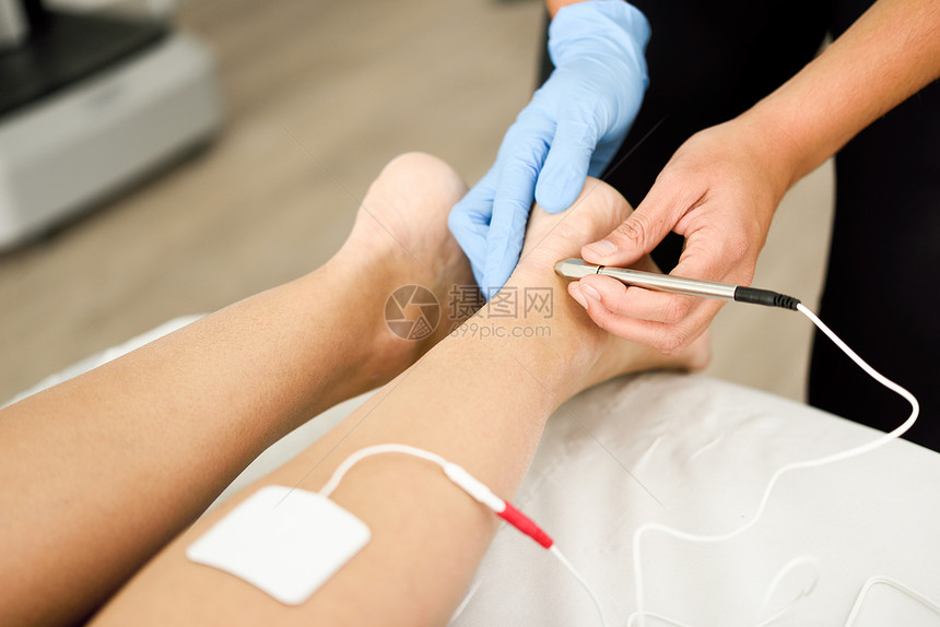 电针干针连接机,针灸师用于女患者针刺,由EPI内经皮电钻引导理疗中心名轻女子踝关节物理治疗中的电刺激图片