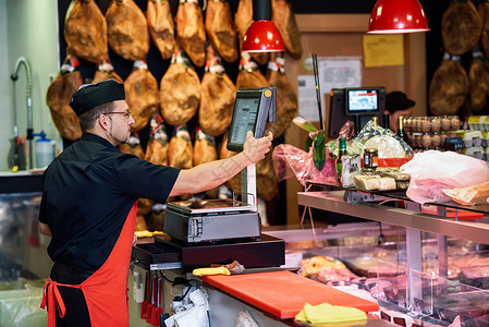 屠夫家肉店里称重肉,并后台用火腿充电图片