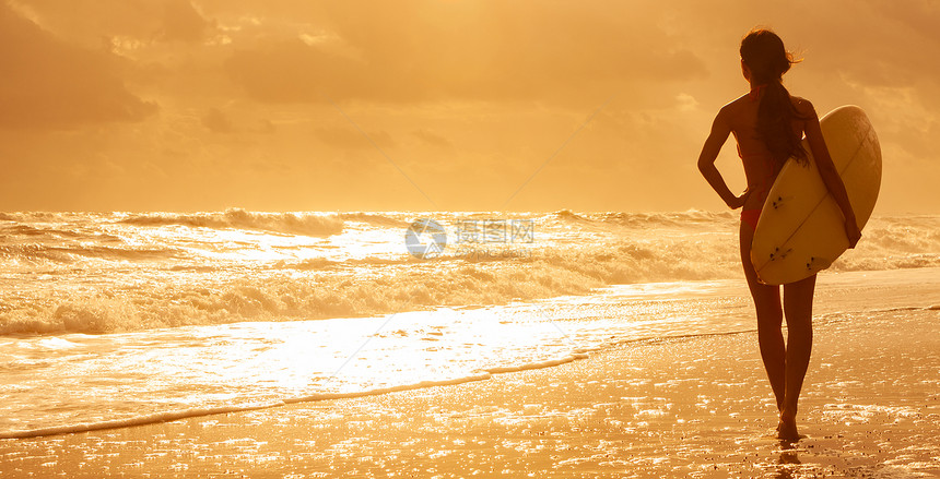 横幅图像后视镜美丽感的轻女子冲浪女孩比基尼与白色冲浪板海滩上日落日出图片