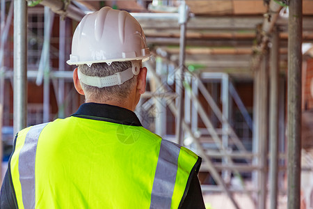 建筑工地上的男建筑工人戴着安全帽背心图片