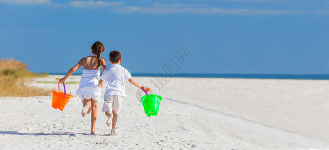 全景快乐的孩子,男孩,女孩,兄弟姐妹跑步,玩得很开心,沙滩上玩桶铲子图片