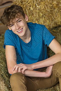 轻人开心地笑着,笑着,男孩子,十几岁的少坐谷仓里的干草捆上图片