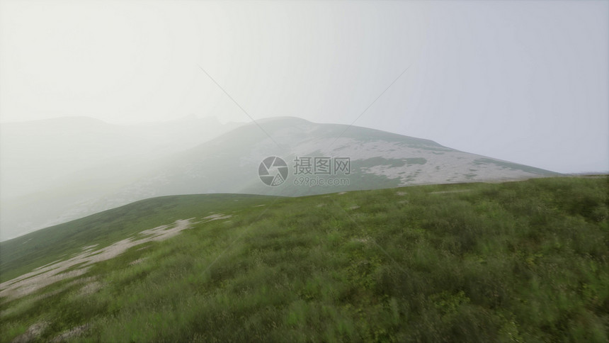 空中视野日落飞越座绿色的草状岩石山丘空中青山景观雾中图片