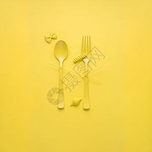 创意静物照片的叉子勺子与生意黄色背景图片