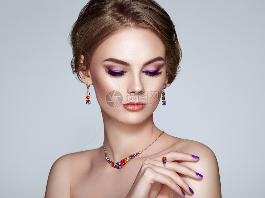 用珠宝描绘美丽的女人模特女孩用紫罗兰指甲修剪指甲优雅的发型紫色化妆箭头美容配饰图片