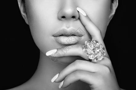 美丽时尚的女人嘴唇与自然化妆白色指甲油光泽蓝色口红美女脸贴着感的嘴唇,修指甲,化妆戒指上宝石,珠宝背景图片