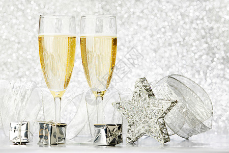 杯香槟银色的礼物闪光的背景上高清图片