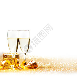 杯香槟装饰的金色丝带隔离白色上图片