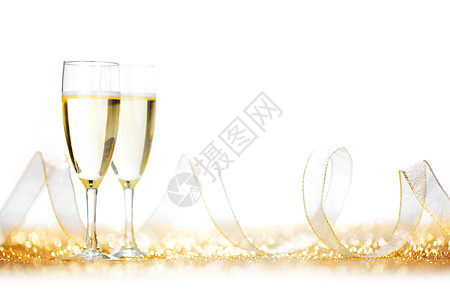 杯香槟丝带上的金色闪光隔离白色图片