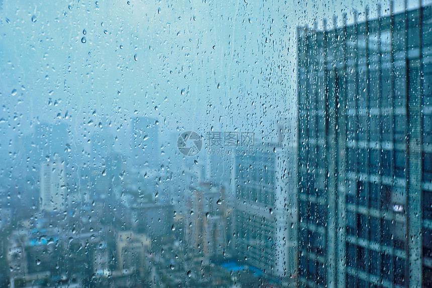 雨水滴窗户璃纹理上,背景摩天大楼雨点落窗户上图片