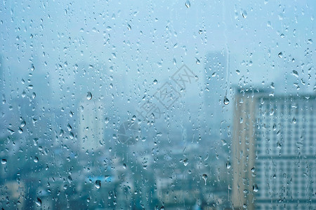 雨水滴窗户璃纹理上,背景摩天大楼雨点落窗户上图片