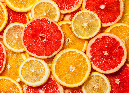 彩色柑橘类水果柠檬,橘子,柚子片背景五颜六色的柑橘类水果片图片