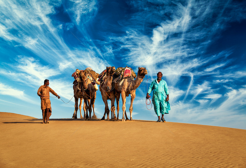 拉贾斯坦邦旅行背景两名印度来客骆驼司机与骆驼塔尔沙漠沙丘贾萨尔默,拉贾斯坦邦,印度两个来客骆驼司机带着骆驼塔尔图片