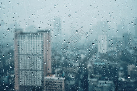 雨水滴窗户璃纹理上,背景摩天大楼雨点落窗户上图片